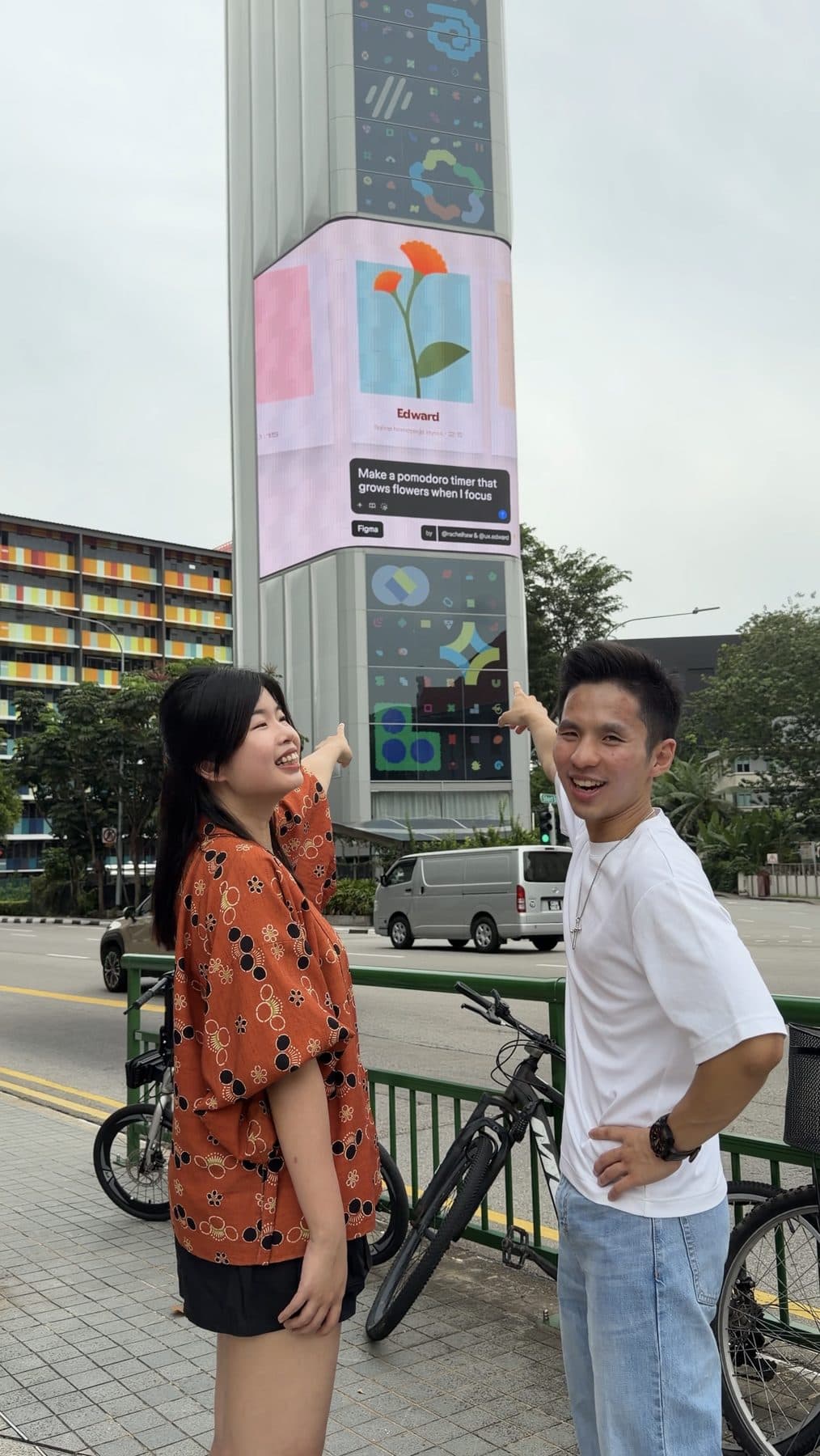Edward with a guest in front of a digital billboard